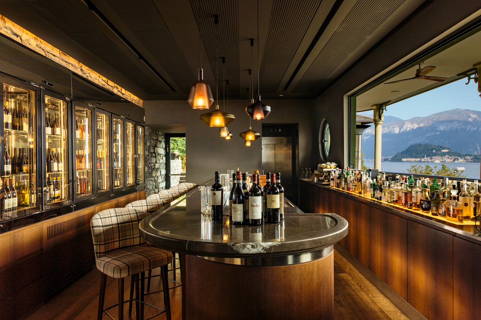 a wood paneled wine bar within lescale overlooking a vista of lake como