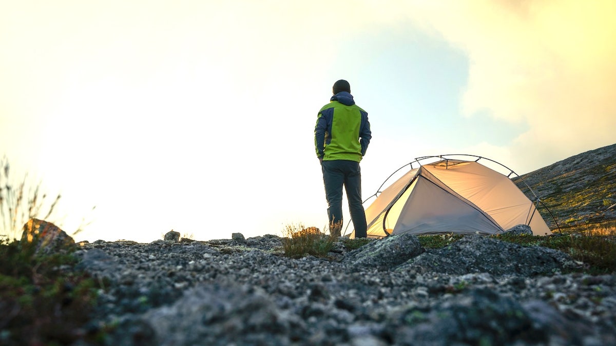 Man camping outdoors with tent