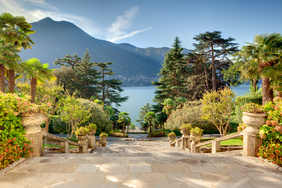 a staircase leading through gardens down to lake como at passalacqua