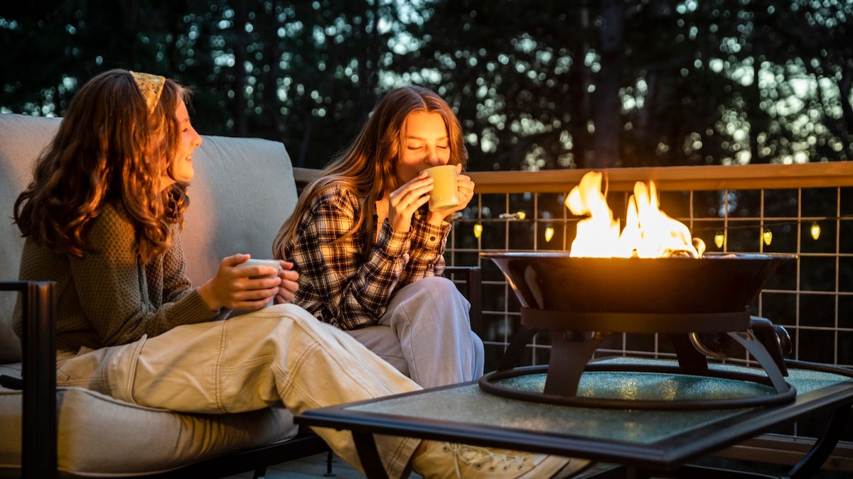 girls sitting by fire pit