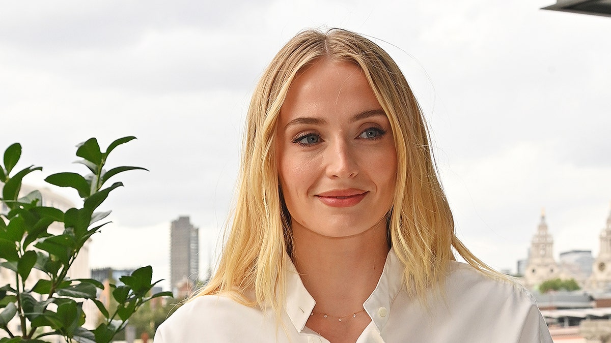 Sophie Turner wears white blouse with necklace