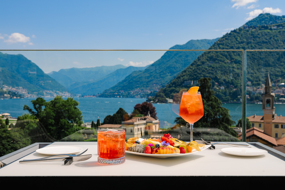 a view of lake como at terrazza 241 featuring two cocktails and a fruit plate