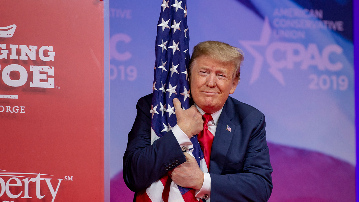 President Trump hugs U.S. flag