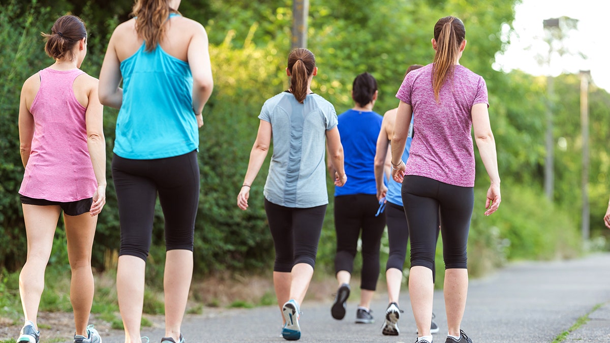 Women walking in a group with their backs facing the camera.