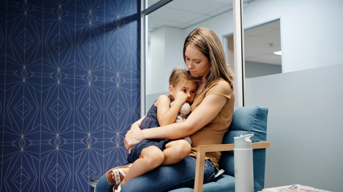 Woman with sick daughter at doctor