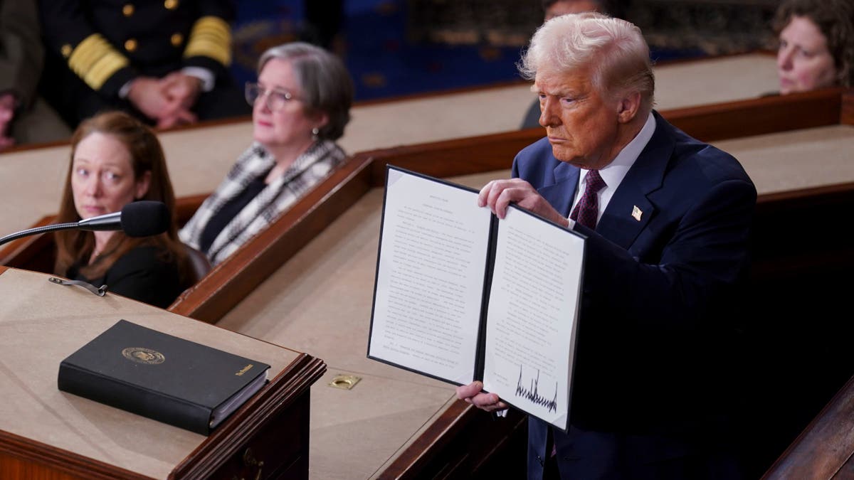 Donald Trump holds a signed executive order