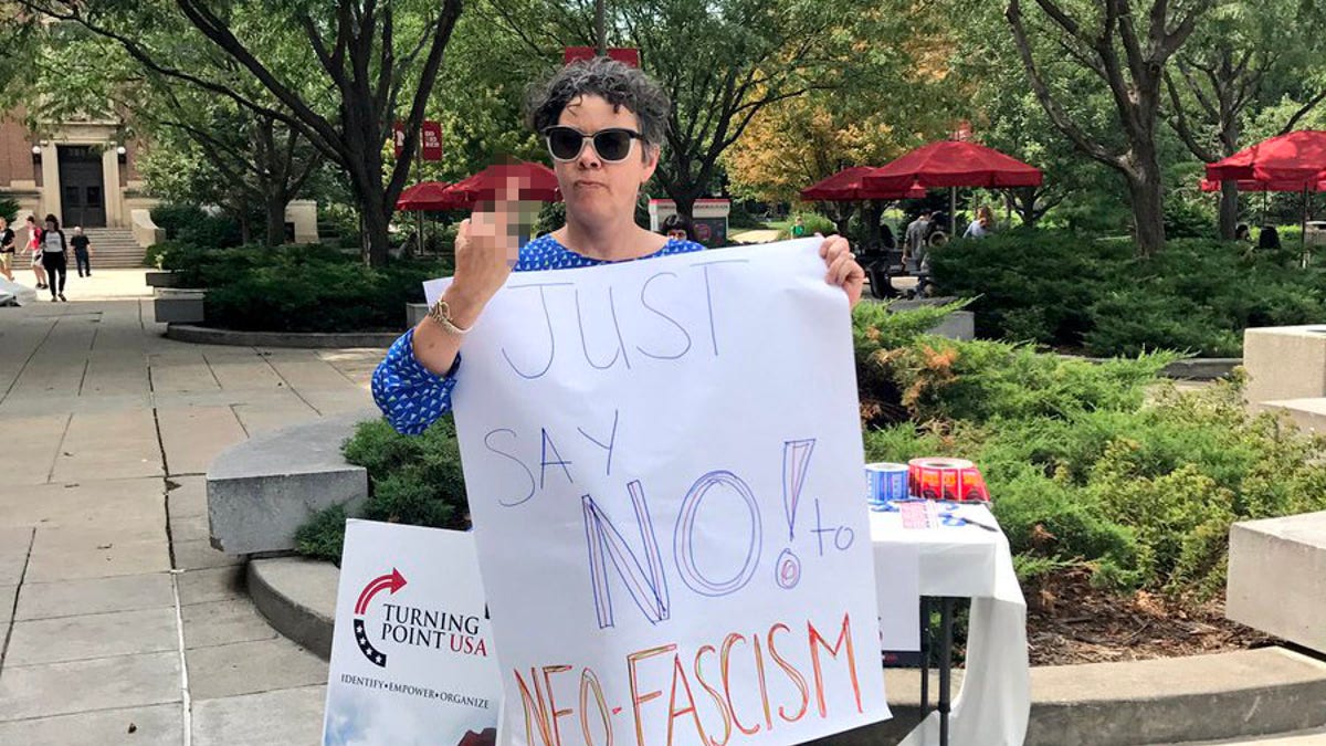 University of Nebraska graduate student Courtney Lawton protesting in front of a recruitment table for the conservative student group Turning Point USA.