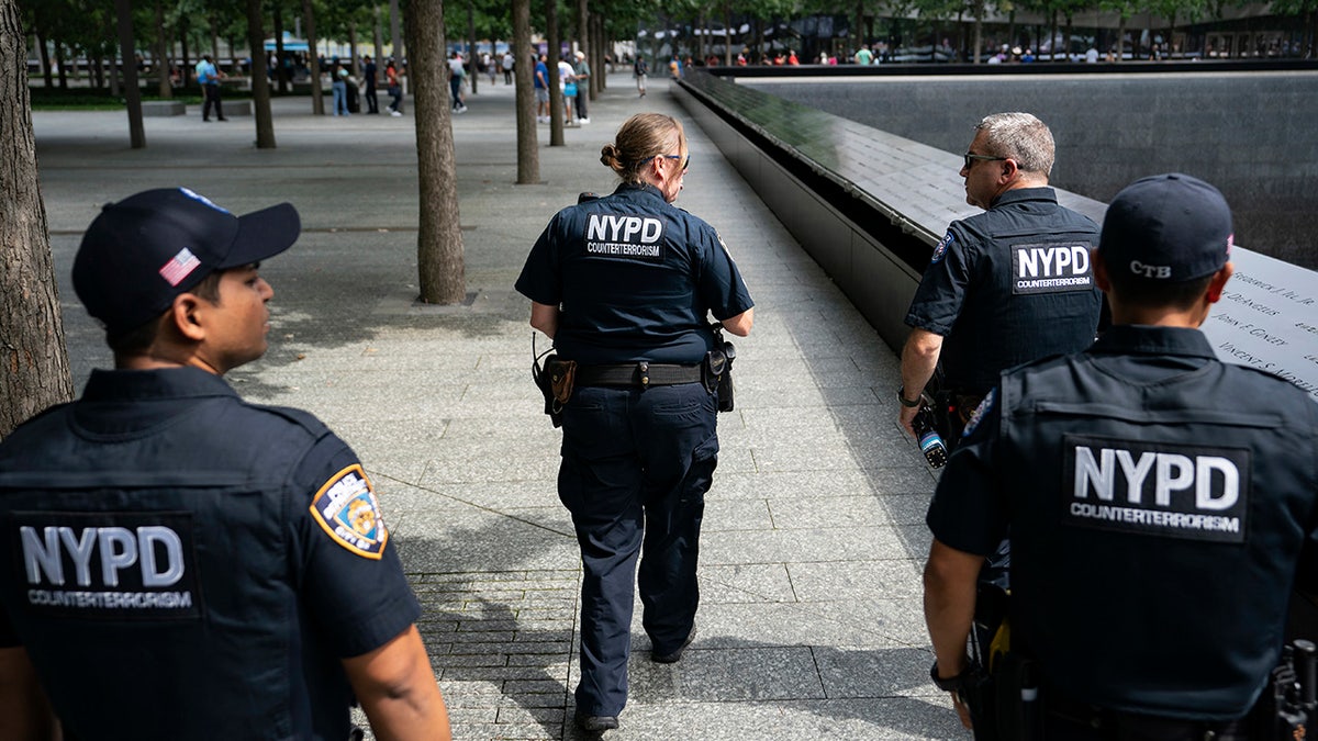 NYPD officer Michael Dougherty, a 25-year veteran, second from right, patrols with his colleagues beside the south reflecting pool of the 9/11 Memorial &amp; Museum on Aug. 16, 2021, in New York.