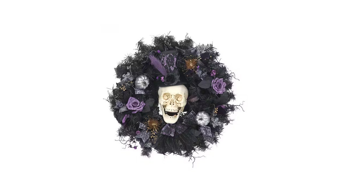 This spooky glam wreath has shimmering pumpkins, roses and skulls. 