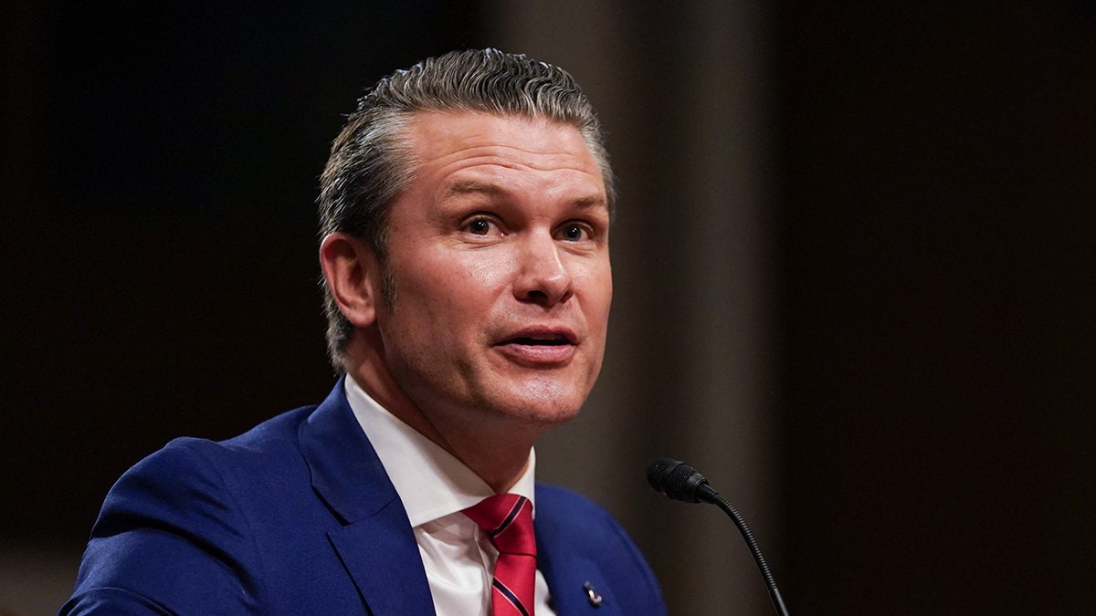 Pete Hegseth speaking while wearing a suit and tie
