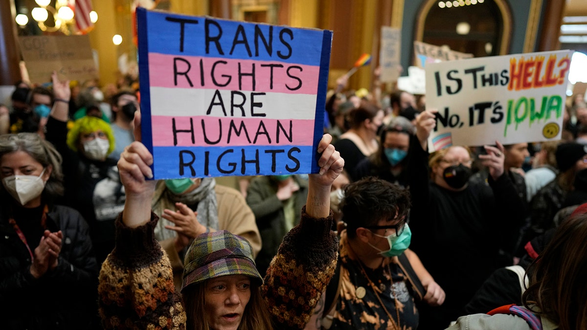 Iowa protesters holding pro-transgender signs