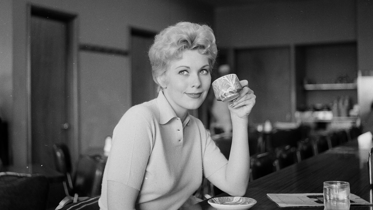 Kim Novak holds a cup of coffee