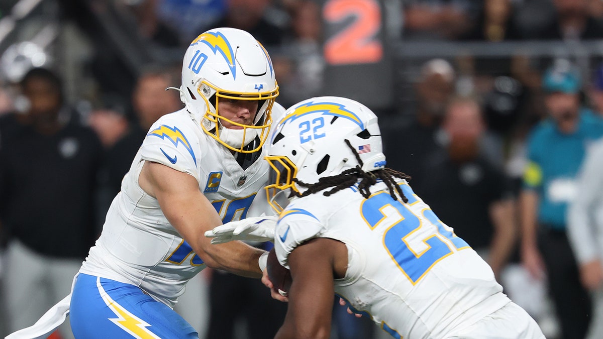 Justin Herbert hands the ball to Najee Harris