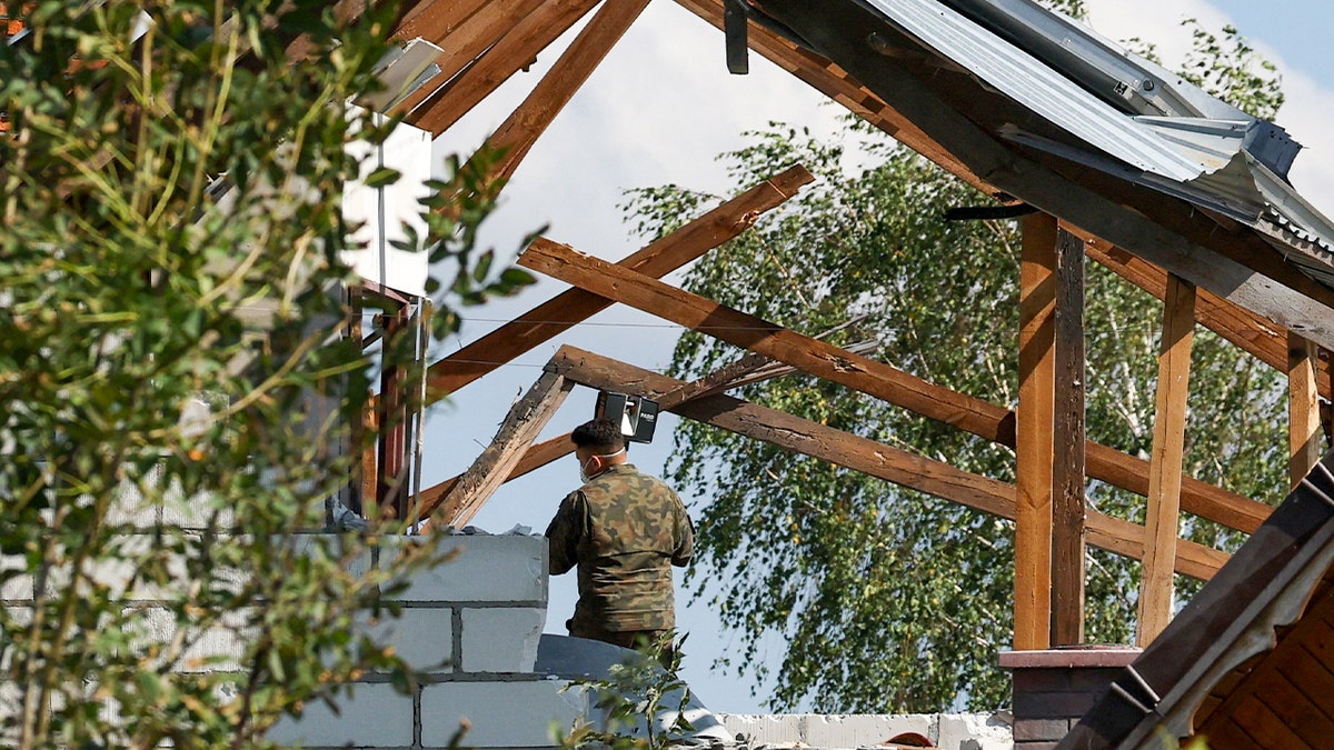 Polish soldier inspects damaged home