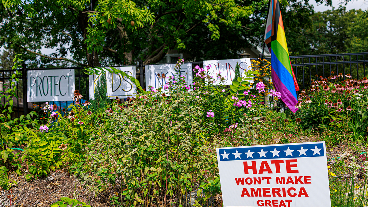 Protest signs and pride flag outside Minneapolis Catholic Church after shooting