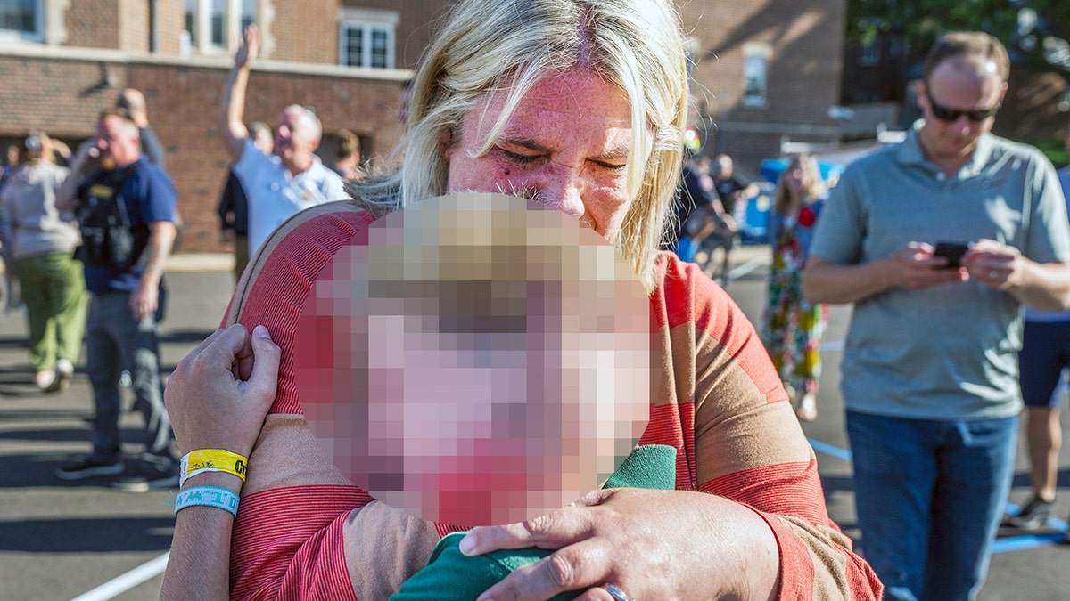Guardian with student after a mass shooting at a catholic school.