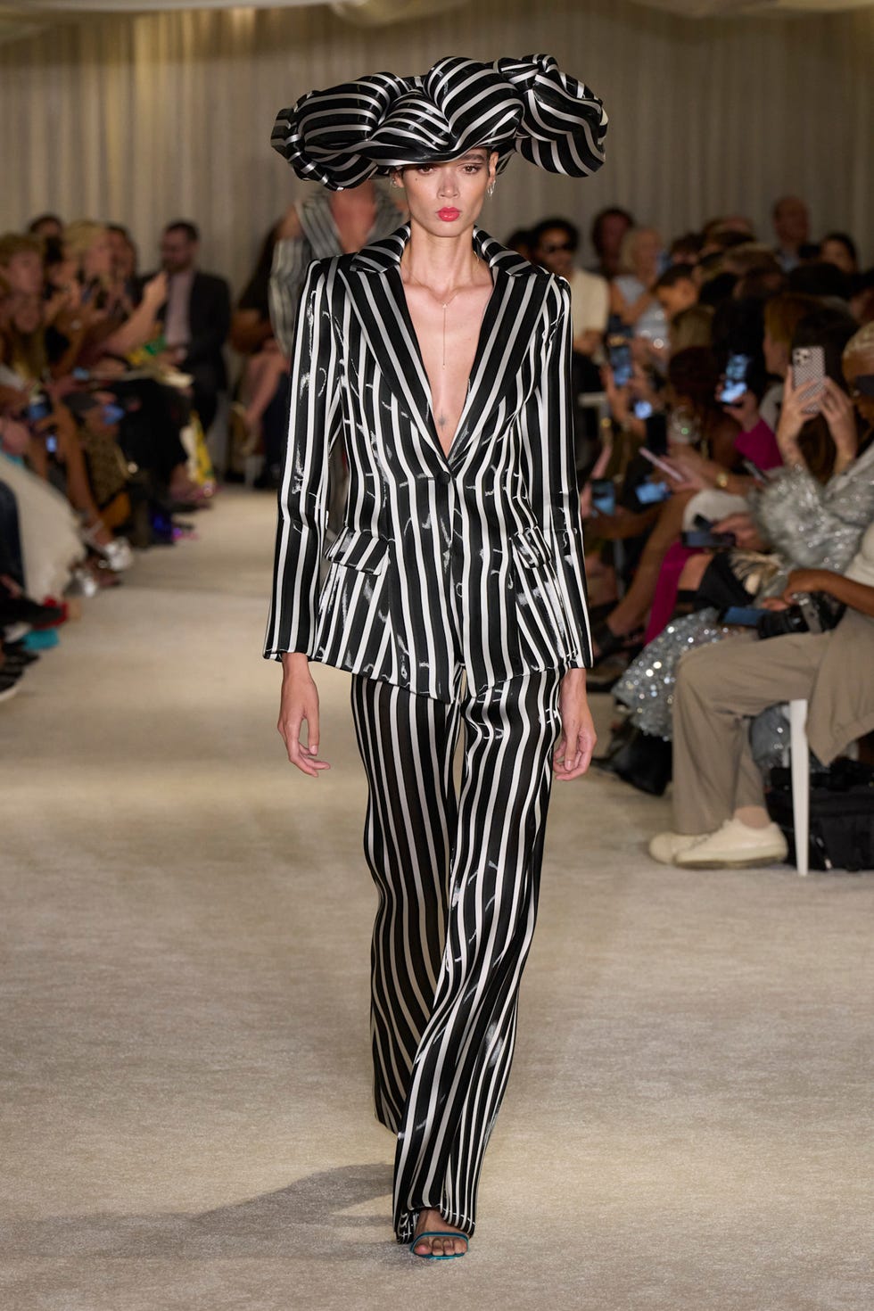 a fashion model showcasing a striking striped suit on a runway