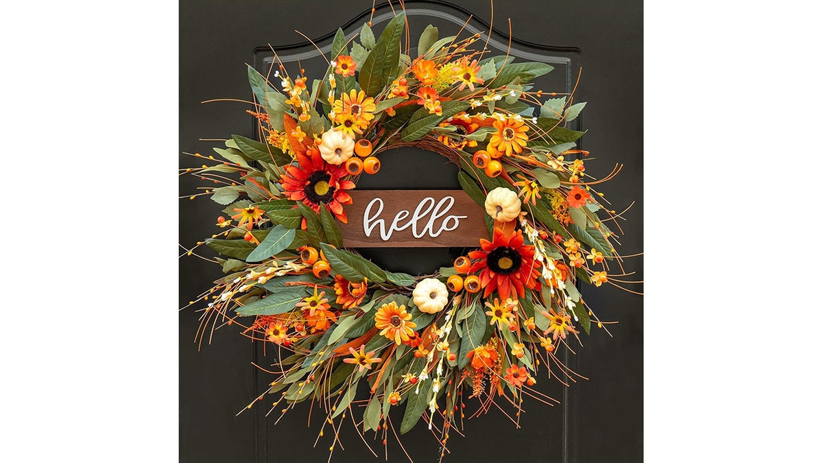 This wreath has a rustic wooden hello sign.