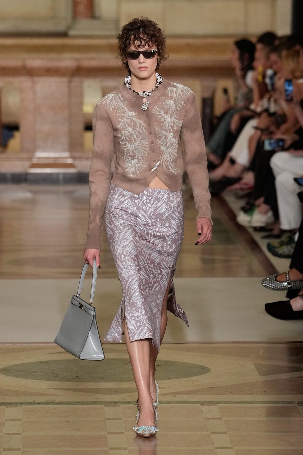 fashion model walking on a runway wearing a stylish outfit