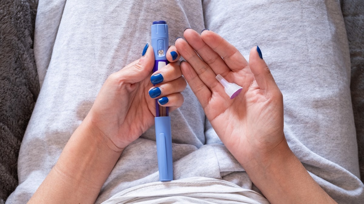 Woman holding GLP-1 medication