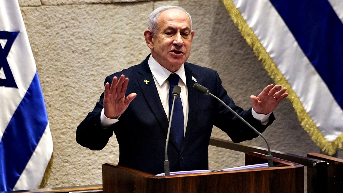 Israeli Prime Minister Benjamin Netanyahu gestures while speaking at a podium