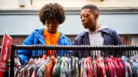Getty Images Stock photo shows two people looking down at a rail of clothes at an outdoor market at an unidentified location in the UK.