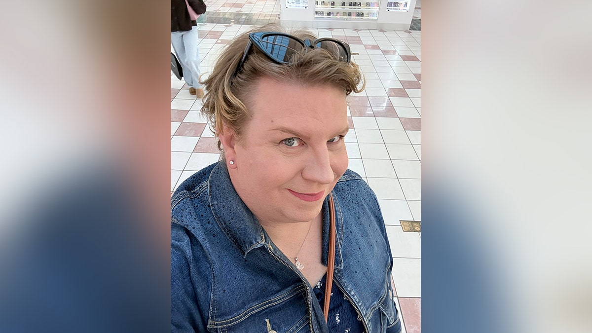 transgender woman wearing denim jacket and sunglasses on head
